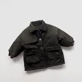 Detailed close-up of dark green children's quilted parka with large cargo pockets and lapel - 80cm / Olive Green