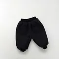 Close-up of black quilted warm pants for children with elastic waist and large side pockets - 80 / Black
