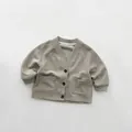 Détail du cardigan gris pour enfants montrant le col en V et la texture des boutons - Gris Avoine / 80cm
