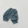 Dettaglio dei pantaloncini cargo in denim lavato per bambini con vita elastica e tasche - 80cm / Blu