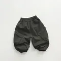 Detalle de pantalón cargo infantil con cintura elástica y bolsillos con solapa - 80cm / Gris Grafito