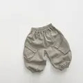 Detalle de los pantalones cargo para niños con cintura elástica y bolsillos laterales - 80cm / Gris Seda de Arroz