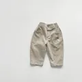 Detailed view of kids khaki cotton trousers featuring elastic waist and button closure - 80cm / Khaki Apricot