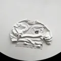 Dettaglio di t-shirt in cotone grigio chiaro con spacchi laterali e stampa mela - 80cm / Beige