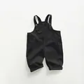 Detail view of black toddler overalls featuring adjustable straps and front pocket - Charcoal Grey / 80cm