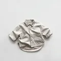 Detail view of beige kids shirt with oversized cargo pockets and asymmetric hem - 80cm / Grey Apricot