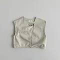 Close-up of minimalist beige cotton vest featuring a unique diagonal button closure - Khaki / 80cm