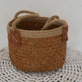 Detail of natural seagrass woven basket featuring brown leather patches and hemp handles - 16*12