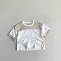 Detailansicht des Kinder-Baumwoll-T-Shirts mit Kontrastkragen und neutralen Nähten - 80cm / Aprikose/Weiß
