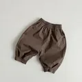 Detail of coffee brown kids cotton loose pants featuring elastic waist and tapered cuffs - 80cm / Black Coffee