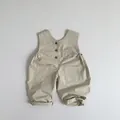 Detailweergave van babyoveralls van katoen en linnen met houten knopen en zakken - 80cm / Licht kaki