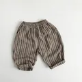 Detailed flat lay of striped cotton-linen kids pants with elastic waist and rolled cuffs - Brown Stripes / 80cm