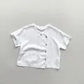 Close-up of kids white linen T-shirt featuring a unique side button placket and wood buttons - 80cm / White