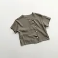 Detailed close-up of a linen kids' shirt with side button closure and rustic texture - 80cm / Taupe