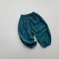 Dettaglio di pantaloni harem larghi per bambini in verde scuro con caviglie elastiche - Verde petrolio / 80cm