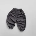 Dettaglio della vita elastica e del morbido tessuto grigio scuro dei pantaloni bimbo - Grigio Caffè / 80cm