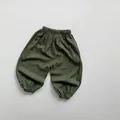 Dettaglio della vita elastica e delle caviglie strette sui pantaloni verdi bambini - Verde pino / 80cm