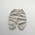 Dettaglio dei pantaloni a quadretti traspiranti per bambini con elastico in vita e polsini - 80cm / Quadretti Albicocca Caffè