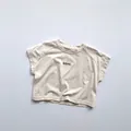 Detail view of cotton fabric texture and HOPE print on minimalist beige kids t-shirt - 80cm / Beige Apricot