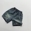 Close-up of vintage dark blue denim shorts featuring elastic waist and raw hem detail - 80cm / Retro Blue