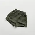 Detail view of olive green kids' cotton shorts with elastic waistband and pockets - 80cm / Moss Green