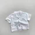 Detail of white cotton kids shirt with black buttons and cafe No.27 chest print - Pure White / 80cm
