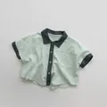 Close-up of mint green cotton linen kids shirt with dark grey contrasting collar and pocket - 80cm / Mint Green