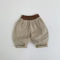 Detail of kids beige lantern pants featuring a brown elastic waistband and cuffed hem - Nut Apricot / 80cm