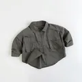 Flat lay of olive green cargo shirt for kids featuring large pockets and button-down collar - Iron Gray / 80cm