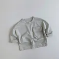 Detailed view of kids crewneck cotton t-shirt with a cargo pocket in beige grey - 80cm / Moonlight White