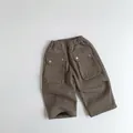 Detail of dark brown kids cargo pants featuring elastic waist and large flap pockets - 80 / Brown