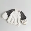 Detail van de ruitvormige stiksels op de schouder van een fleece kindersweatshirt - 80cm / Broken Wit