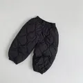 Detail van zwarte gewatteerde kinderbroek met elastische tailleband en golfstructuur - 80cm / Zwart