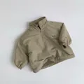 Détail de sweat en polaire enfant kaki clair avec demi-zip et broderie Pluto sur la poitrine - 80cm / Kaki