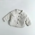 Detalle de chaqueta de pana beige acolchada para niños con cuello, botones y textura - Blanco Crema / 80cm