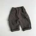 Dettaglio dei pantaloni cargo per bambini con vita elastica e tasche laterali a patta - 80cm / Verde Grigastro