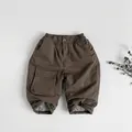 Detailed view of kids warm cotton winter trousers with thick fleece lining and cargo pockets - 80cm / Brown