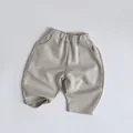 Detail of kids knit joggers featuring an elastic waistband and curved side pockets - 80 / Apricot