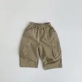 Detailed view of kids cargo pants featuring elastic waist and large side flap pockets - 80cm / Khaki