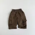 Detailed view of kids' brown cargo shorts featuring elastic waist and utility side pockets - 80cm / Dark Coffee