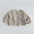 Vue détaillée d'une veste enfant beige en coton avec grandes poches rondes - 80cm / Crème