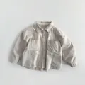 Detail eines gestreiften Baby-Baumwollhemdes mit aufgesetzten Taschen und Knopfleiste - 80cm / Aprikose Grau Gestreift