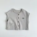 Detail of grey knitted kids vest showing brown buttons and UNITE printed text - 80cm / Cloud Grey