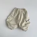 Détail du pantalon cargo enfant en coton avec taille élastique et poche latérale à rabat - Abricot Beige / 80cm