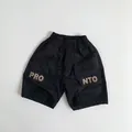 Detail of kids black cargo shorts featuring elastic waist and PRO letter print on pockets - Black / 80cm