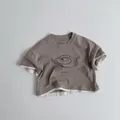 Detail view of cotton t-shirt with greyish-brown fabric, round neck and star print - Milk Tea / 80cm