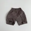 Dettaglio dei pantaloncini cargo per bambini con vita elastica a coulisse e ampie tasche - 80 / Marrone