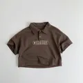 Détail d'un polo marron en coton pour enfants avec impression de lettres comma - 80cm / Marron