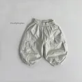 Detailed view of beige cargo joggers featuring elastic waist and utility flap pockets - Apricot / 80cm