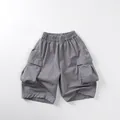 Detail view of children's grey cargo shorts with elastic waist and large side flap pockets - 80cm / Smoke
